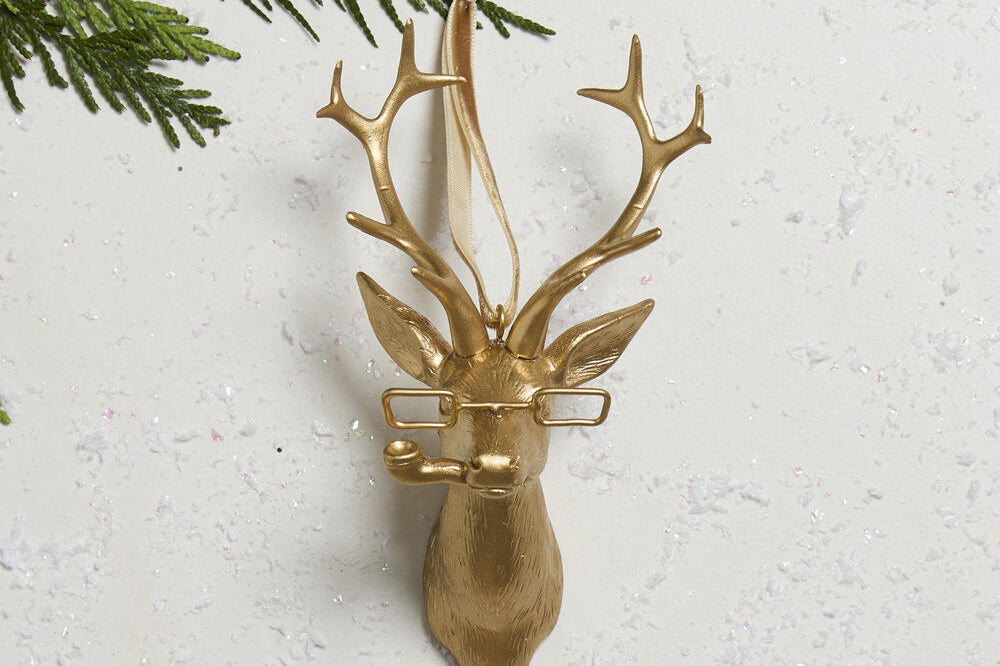E + E Ornaments, third view, the gold buck with spectacles hanging on a cedar branch