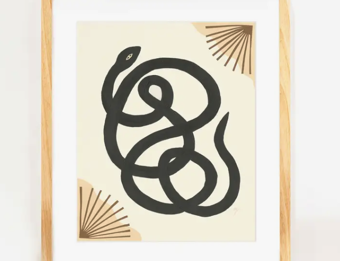 Elana Gabrielle Garden Variety Print, a black snake with gold fans on cream, in a natural wood frame