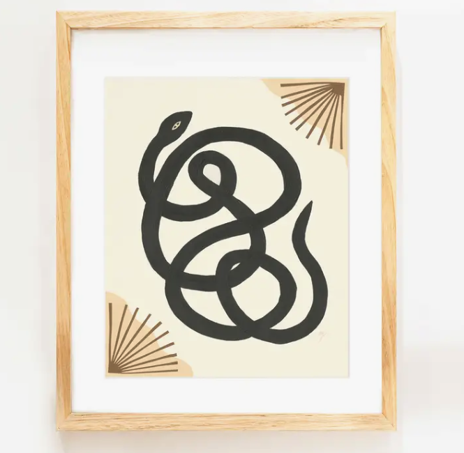 Elana Gabrielle Garden Variety Print, a black snake with gold fans on cream, in a natural wood frame