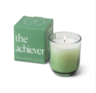 Green boxed Paddywax Enneagram candle labelled the achiever, with a lit candle beside it