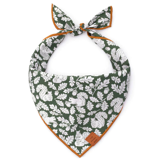 Foggy Dog Dog Bandana in Squirrel, a dark green tie-on bandana with a white squirrel and leaf print