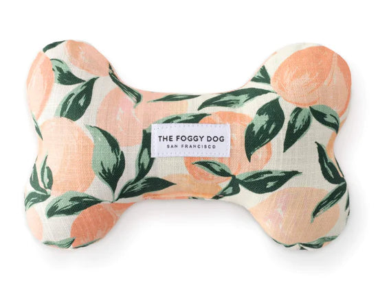 Foggy Dog Dog Squeaky Toy in Peaches and Cream, a plush bone with a peach and leaf print
