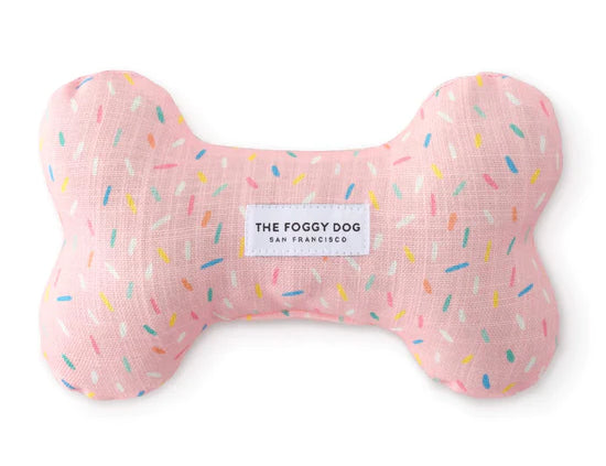 Foggy Dog Dog Squeaky Toy in Sprinkles, a pink plush bone with a colorful sprinkle print