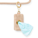 Foggy Dog Poop Bag Holder in Sand Waxed clipped to a leash with a bag pulled through the grommet