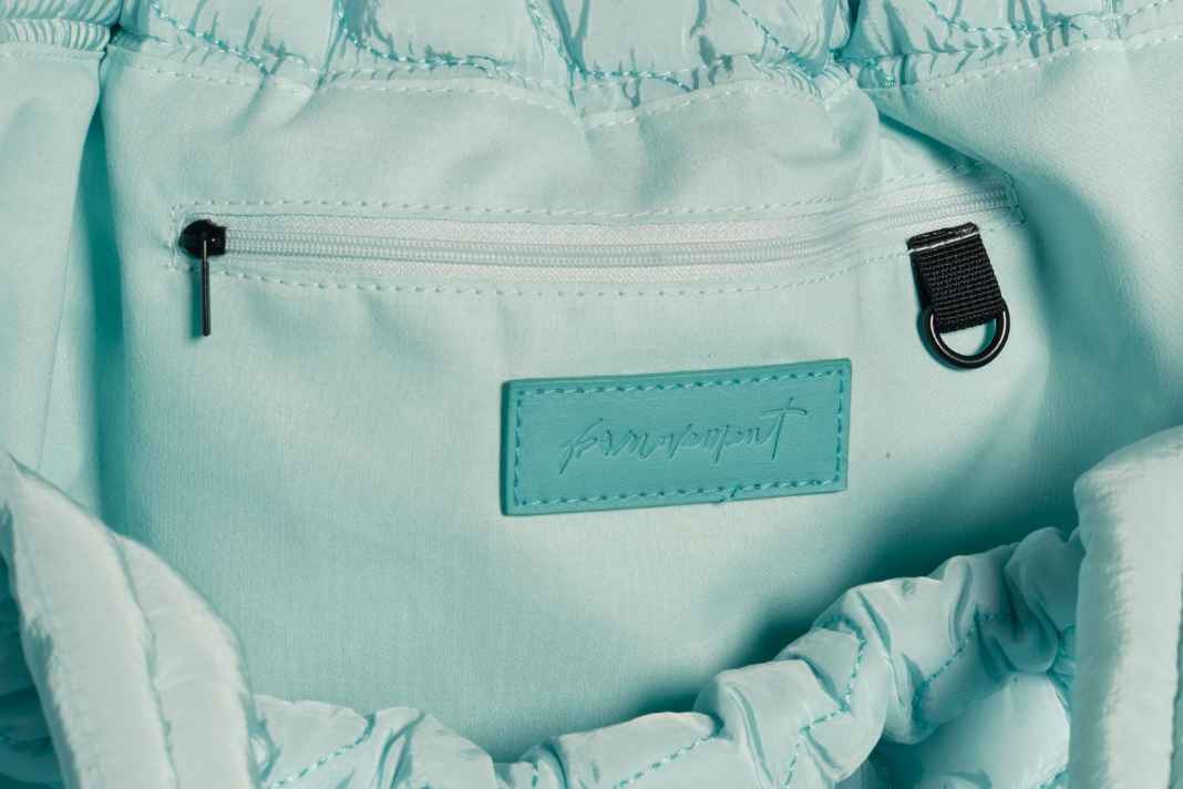 Free People Movement Cloud 9 tote in pistachio, close up of the gathered drawstring top and label