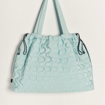 Free People Movement Cloud 9 quilted tote in pistachio, hanging by its long shoulder straps