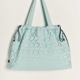 Free People Movement Cloud 9 quilted tote in pistachio, hanging by its long shoulder straps