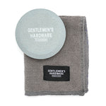 Gentlemen's Hardware Sharpening Stone, a round gray stone with a gray cleaning cloth