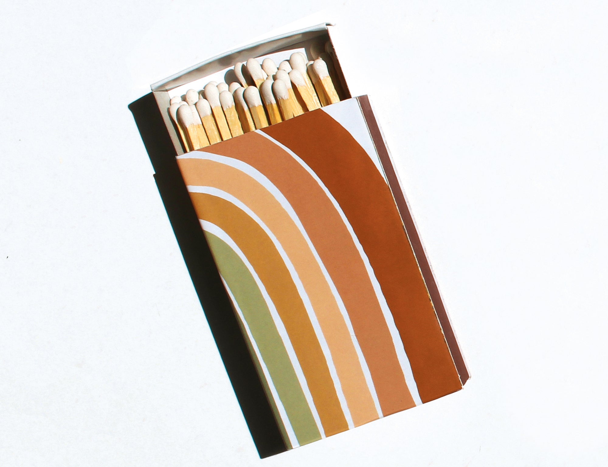 GP Candle Co Desert Rainbow Matchbox, a matchbox with a rust, orange and sage rainbow stripe design, partly open