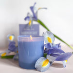 GP Candle Co Midnight 9oz Candle lit and surrounded by purple irises