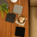 Graf Lantz Bierfilzl Square Coasters in Noir on a wooden table with an iced drink and greenery