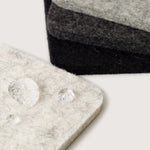 Close-up of water droplets beading on the Graf Lantz Bierfilzl Square Coasters in Noir