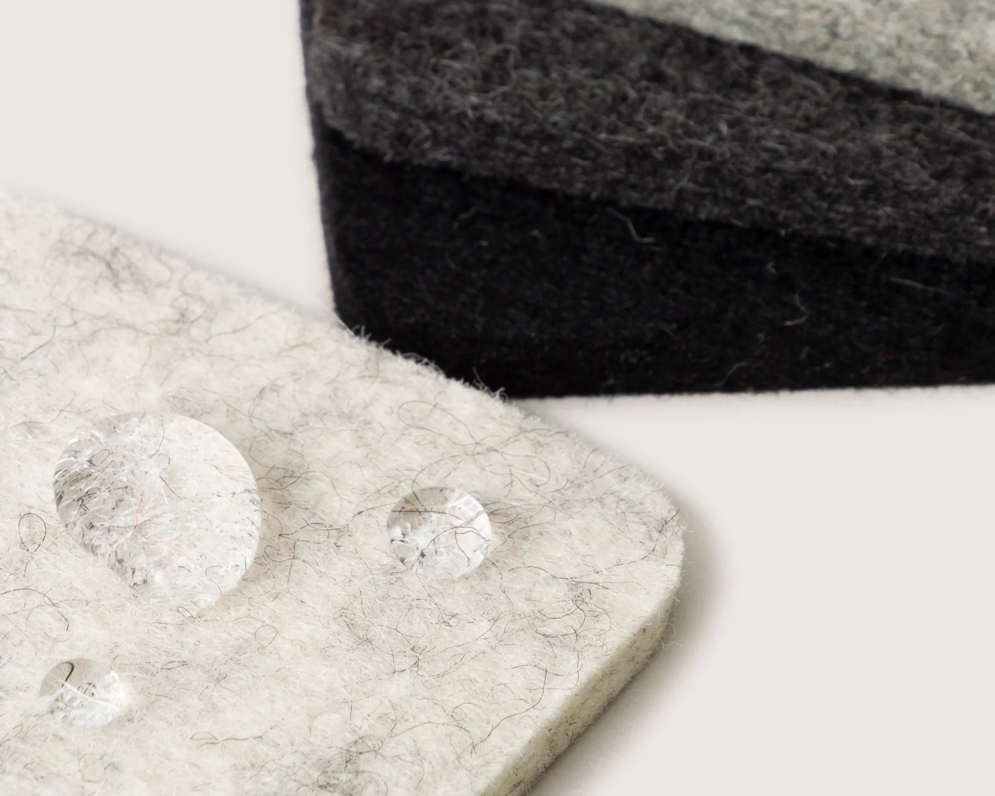 Close-up of water droplets beading on the Graf Lantz Bierfilzl Square Coasters in Noir