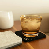 Graf Lantz Bierfilzl Square Coaster in black under a glass of whiskey on a side table