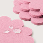 Close-up of Graf Lantz Coaster Crest coasters in Mauve stacked, with water droplets beading on the felt