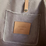 Close-up of the leather Graf Lantz label and rivet on the Hana Canvas Boat Bag in gray