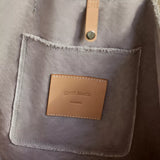 Close-up of the leather Graf Lantz label and rivet on the Hana Canvas Boat Bag in gray