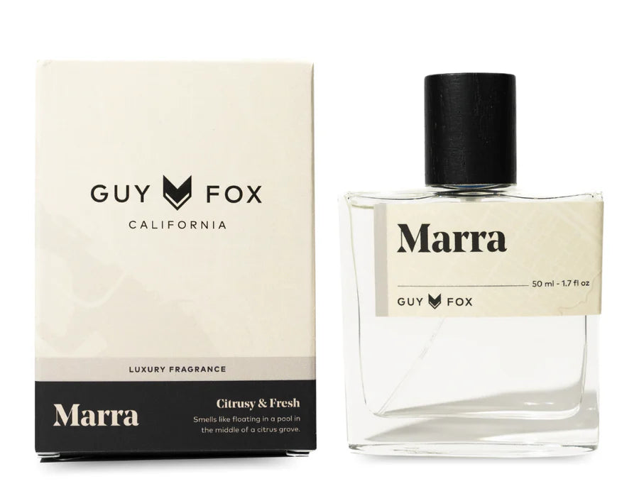 Guy Fox Marra Cologne, a clear glass bottle with a black cap beside its cream and black box