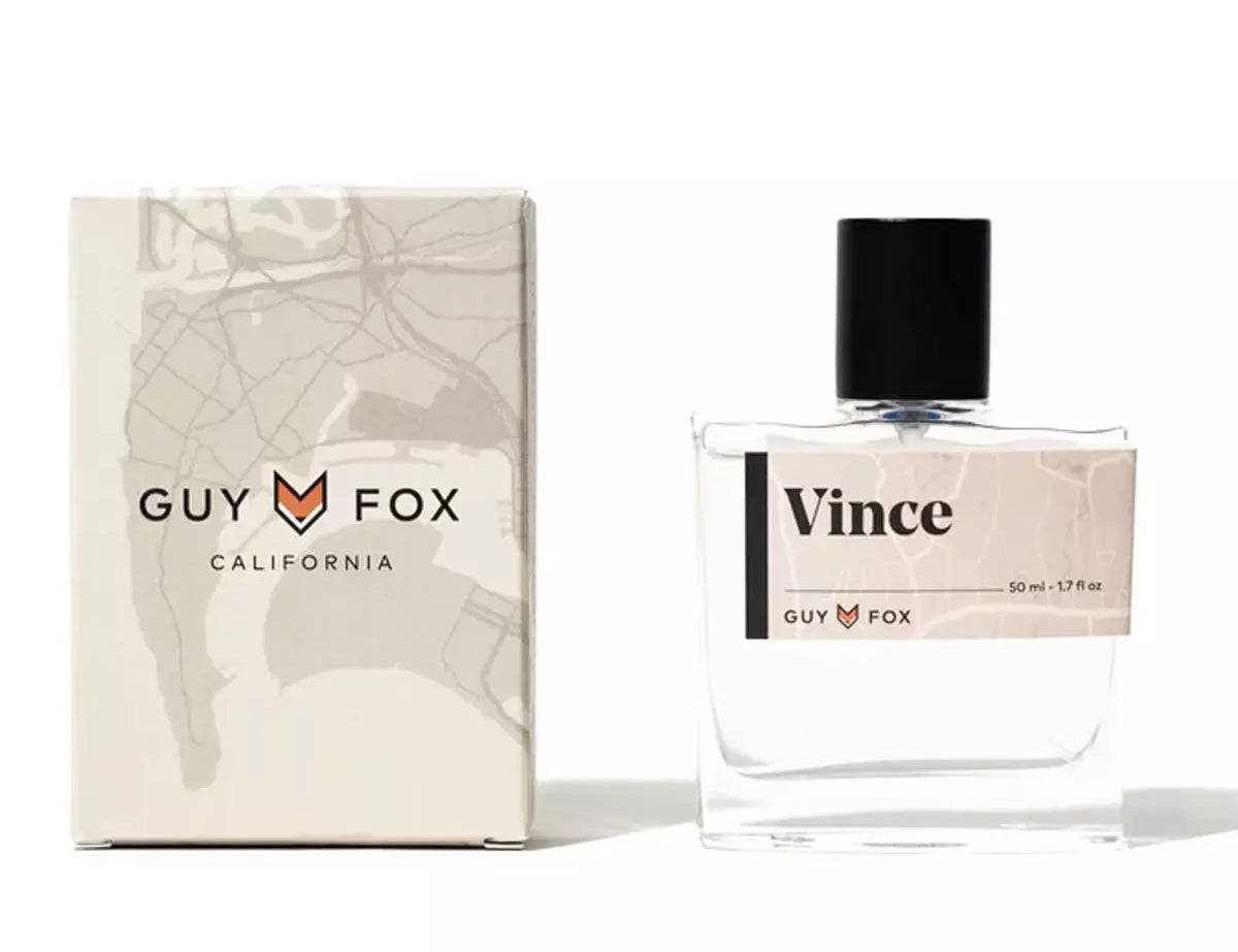 Guy Fox Vince Cologne, a clear glass bottle with a black cap beside its cream and black box