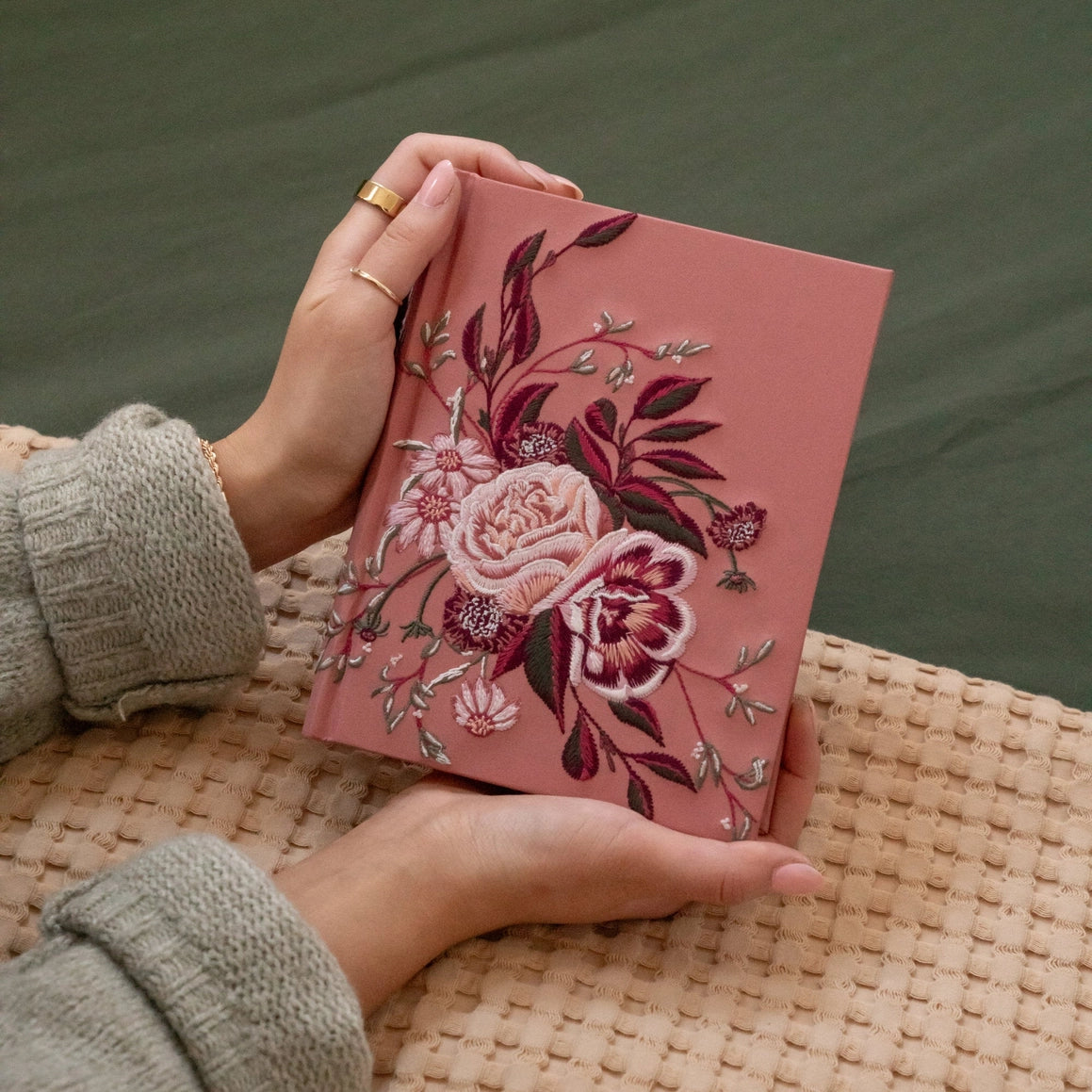 Hands holding the Hosanna Revival CSB Notetaking Bible in the Rosedal theme