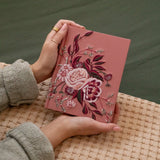 Hands holding the Hosanna Revival CSB Notetaking Bible in the Rosedal theme