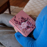 Person in a blue sweater holding the Hosanna Revival CSB Notetaking Bible Rosedal theme in their lap