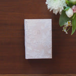 Hosanna Revival NLT Compact Bible Casablanca theme on a dark wood table with white flowers