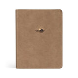 Hosanna Revival NLT Notetaking Bible in the Galilee theme, a tan faux leather cover with a gold sunrise emblem