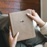 Hands holding the Hosanna Revival NLT Notetaking Bible in the Galilee theme