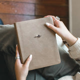 Hands holding the Hosanna Revival NLT Notetaking Bible in the Galilee theme