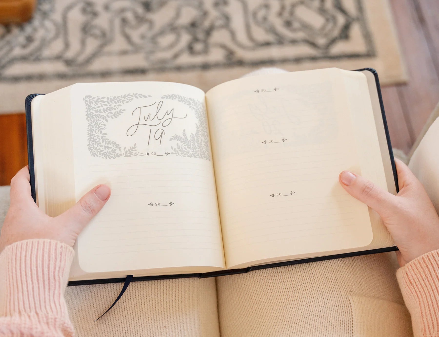 Hands holding the Hosanna Revival One Thing I Ask prayer journal open to a July 19 page