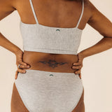 Close-up back view of the Huha Mineral Bikini underwear and bralette in Grey with hands on hips