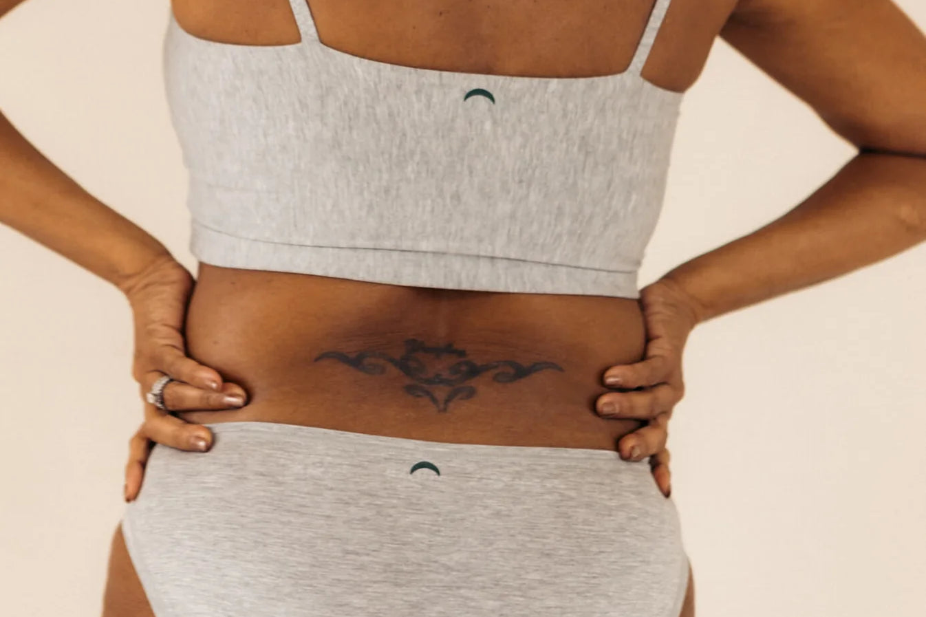 Close-up back view of the Huha Mineral Bikini underwear and bralette in Grey with hands on hips