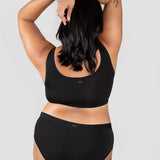 Back view of a woman wearing the Huha Mineral Cheeky underwear and bralette in Black