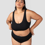 Front view of a woman wearing the Huha Mineral Cheeky underwear and scoop bralette in Black