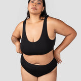 Front view of a woman wearing the Huha Mineral Cheeky underwear and scoop bralette in Black