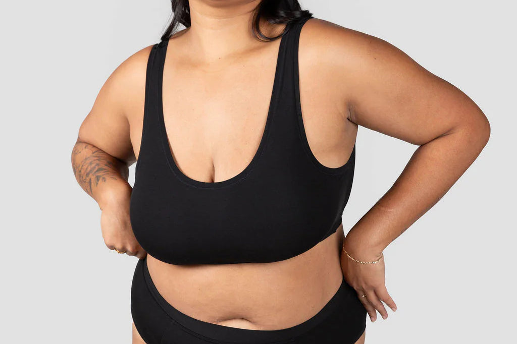 Front view of a woman wearing the Huha Mineral Cheeky underwear and scoop bralette in Black