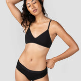 Woman with hand behind her head wearing the Huha Mineral Cheeky underwear and bralette in Black
