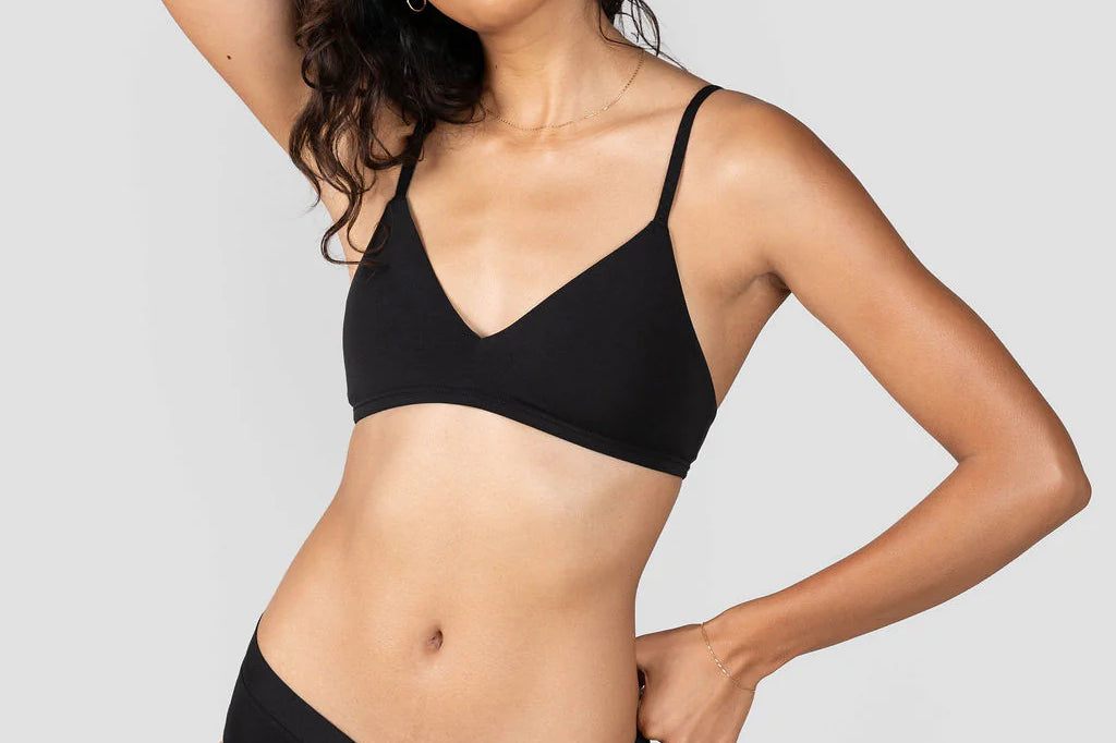 Woman with hand behind her head wearing the Huha Mineral Cheeky underwear and bralette in Black
