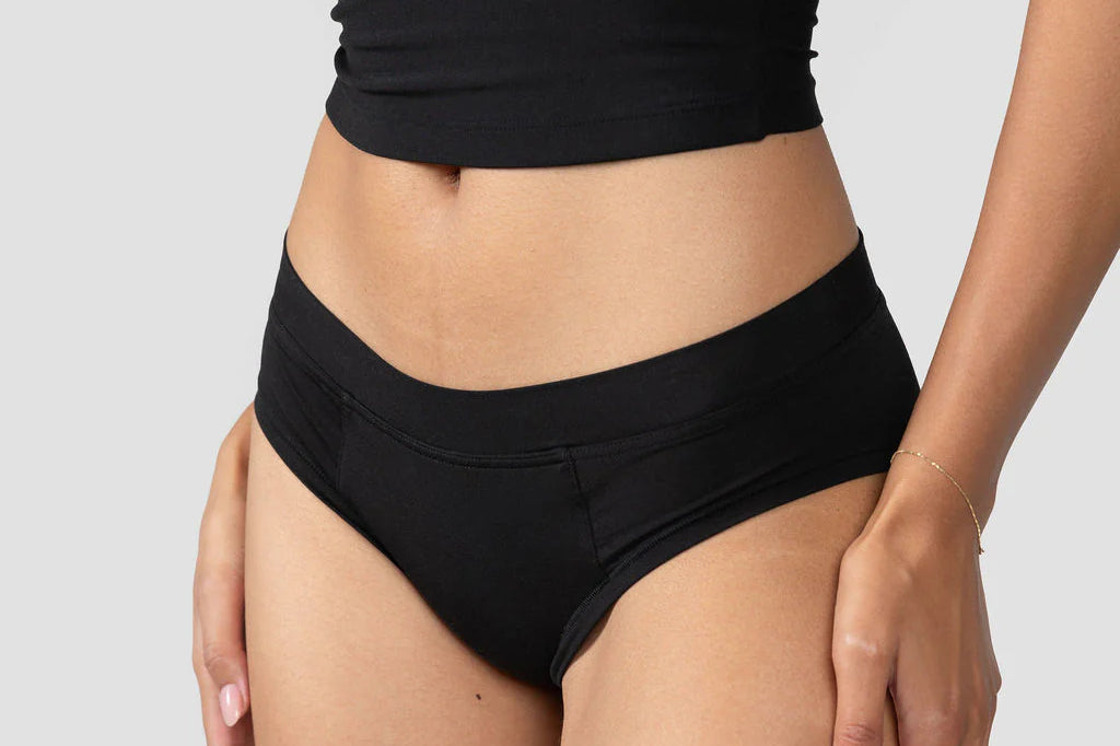 Front view of the Huha Mineral Cheeky underwear in Black worn with a black tank