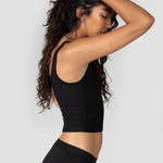 Side view of a woman wearing the Huha Mineral Cheeky underwear and tank in Black