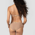 Back view of a woman with long curly hair wearing the Huha Mineral Cheeky underwear and bra in Tan