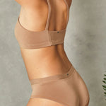 Side view of a woman wearing the Huha Mineral Cheeky underwear and racerback bralette in Tan
