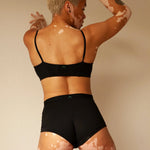 Back view of a woman wearing the Huha Tata Bralette and boxer briefs in Black