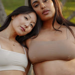 Two women outdoors wearing the Huha Tata Bralette in White and Tan