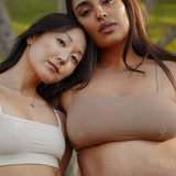 Two women outdoors wearing the Huha Tata Bralette in White and Tan