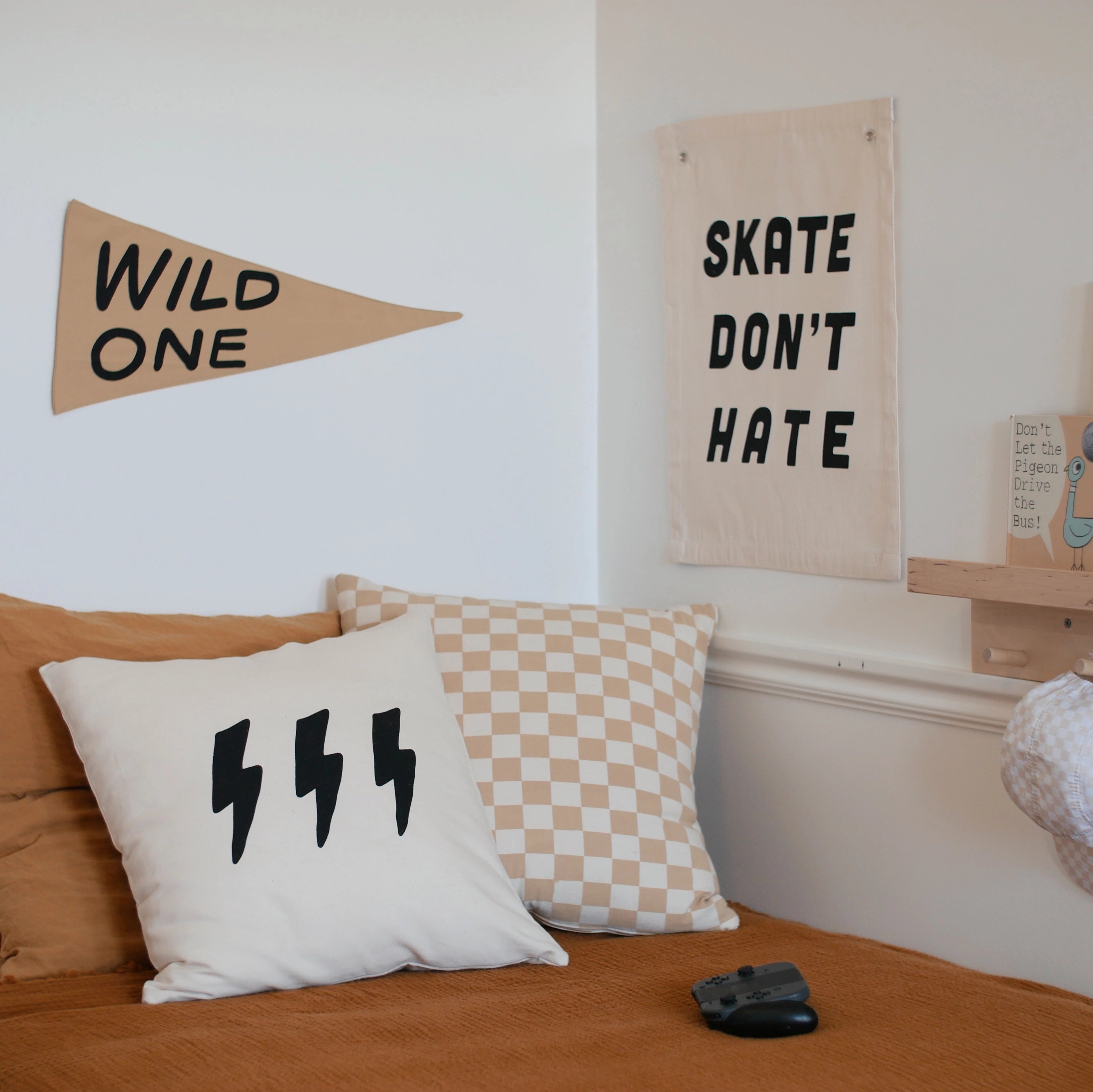Imani Collective Wild One Pennant on a bedroom wall beside a Skate Don't Hate banner