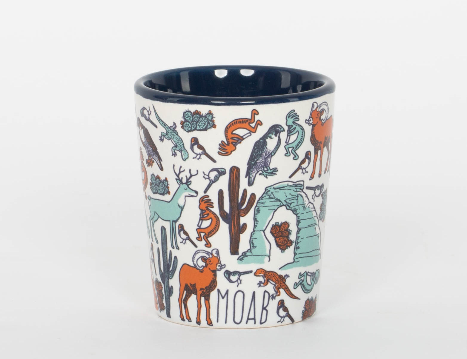 Cream ceramic Moab shot glass patterned with bighorn sheep, deer, lizards and cacti