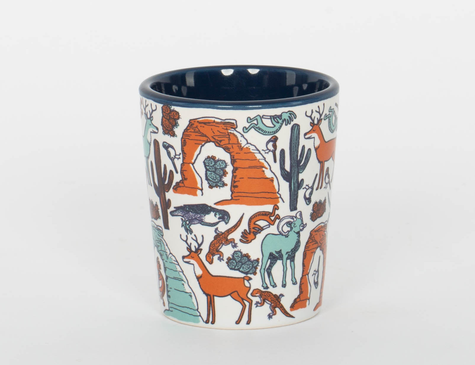 Cream ceramic Moab shot glass patterned with bighorn sheep, deer, lizards and cacti, second view