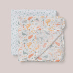 Jujube Roarsome Swaddle Blanket Set, two folded muslin swaddles with a colorful dinosaur print
